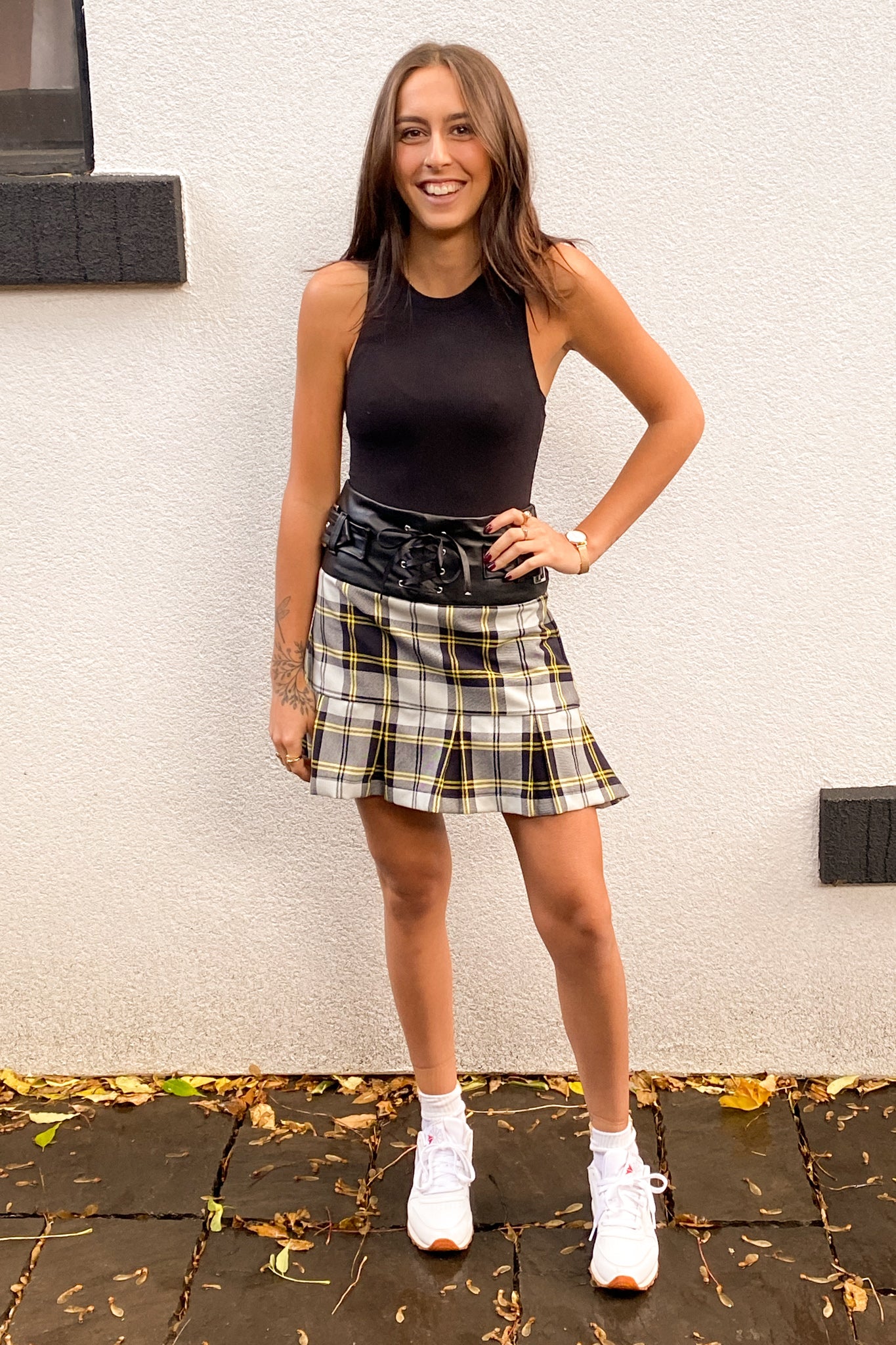 Alternate front view of the model wearing a plaid mini skirt