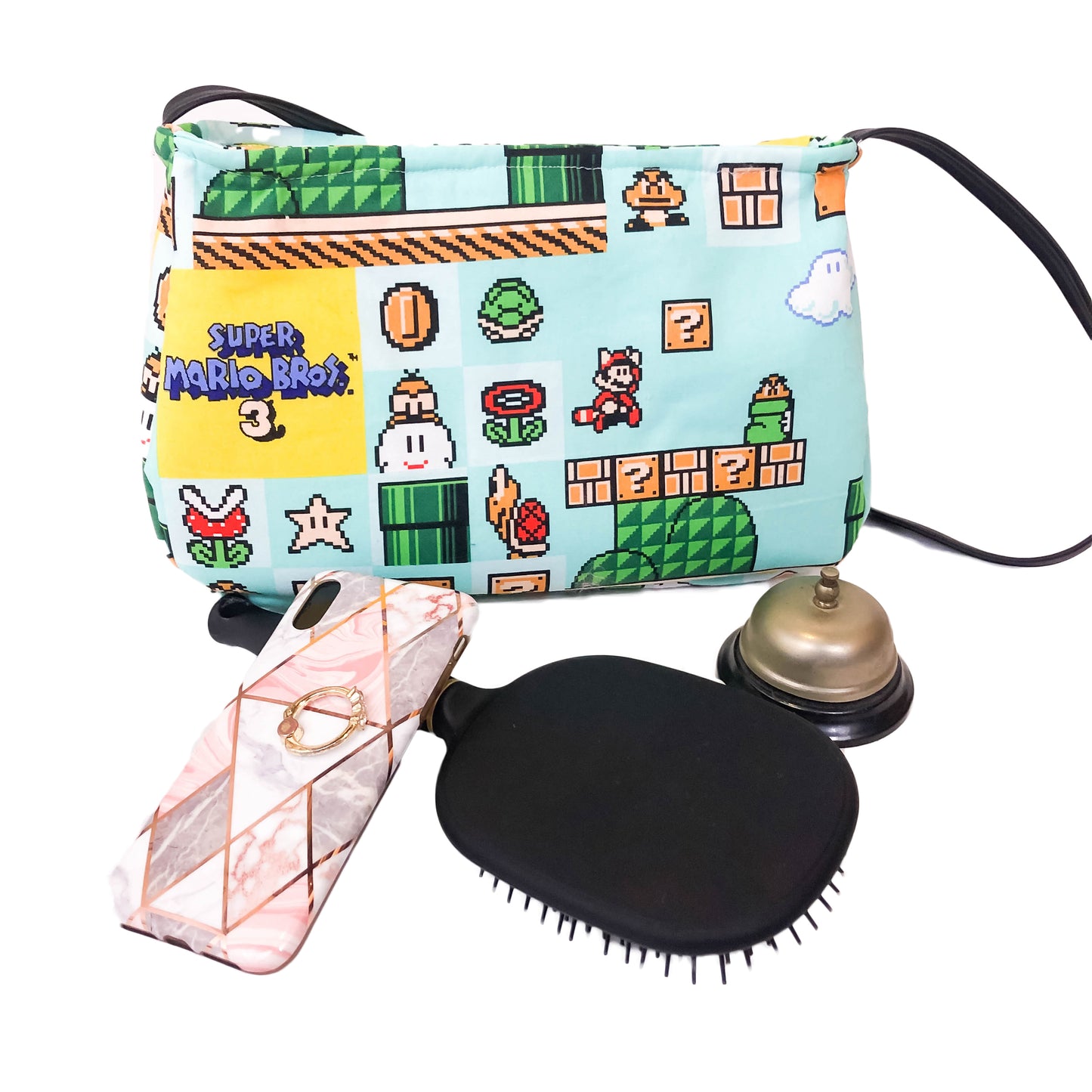 Front view of a fabric purse with a Super Mario Bros 3 motif surrounded by objects one might keep in a purse