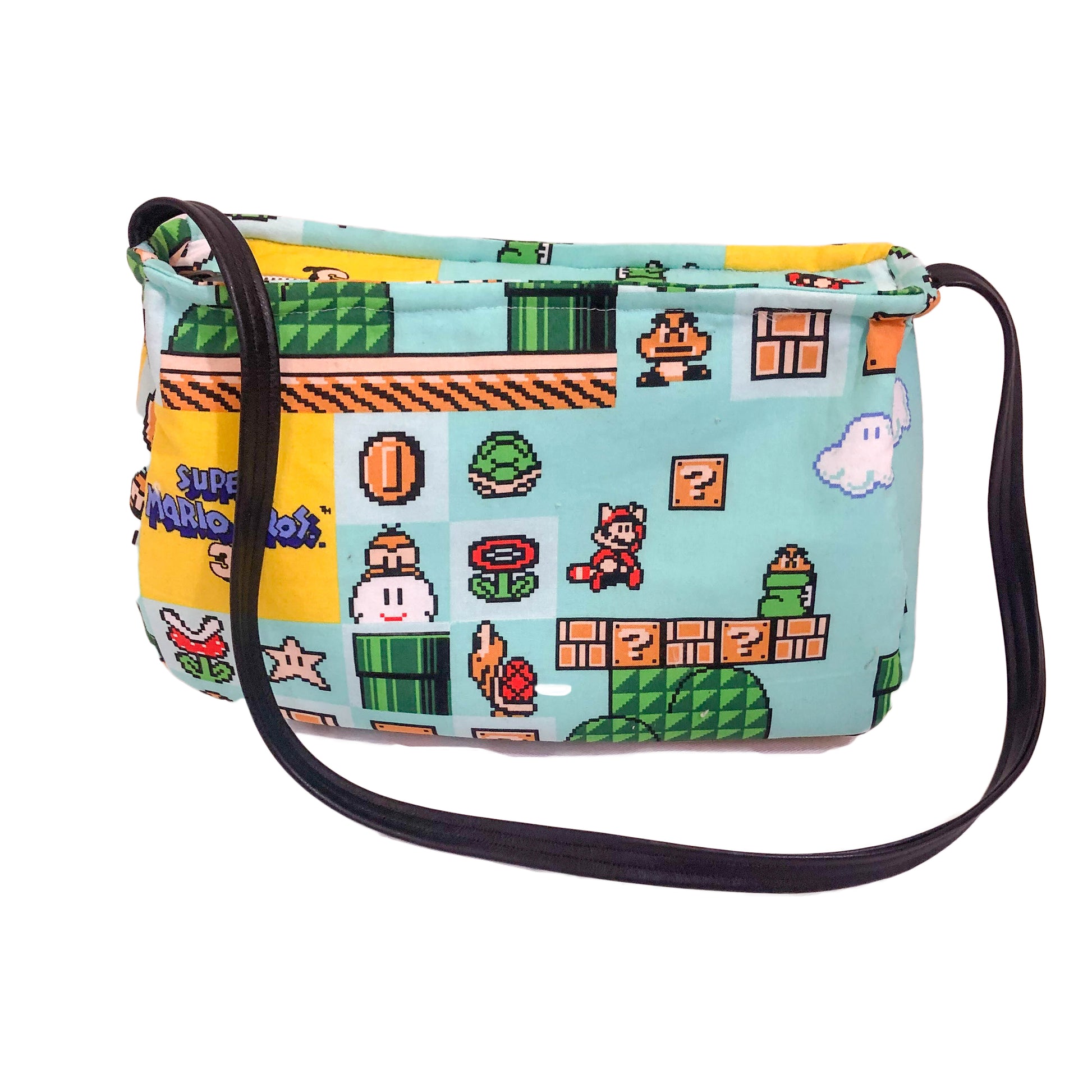 Front view of a fabric purse with a Super Mario Bros 3 motif