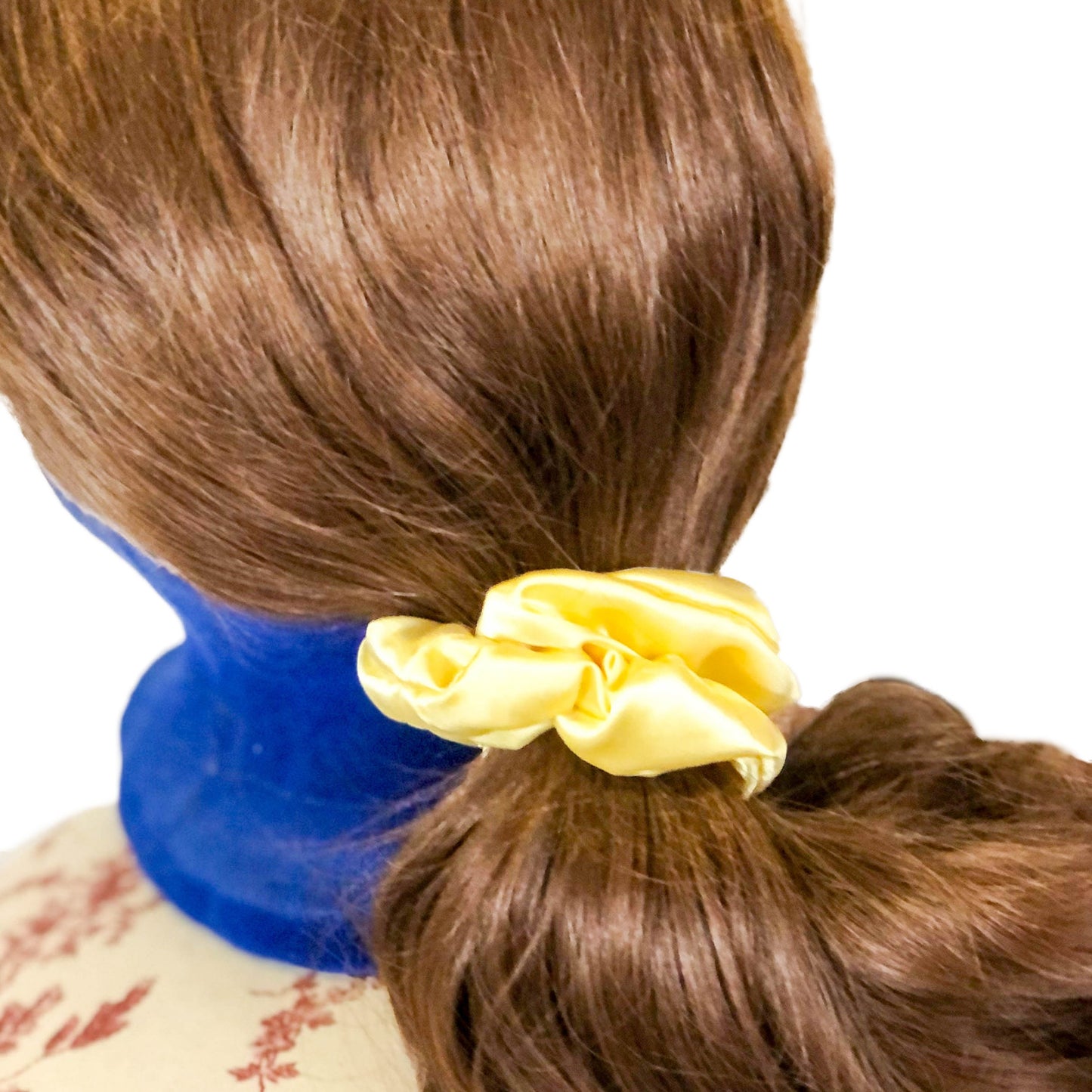 Photo of a scrunchie made of pale yellow satin on a wig