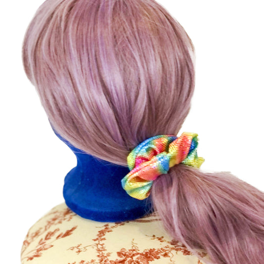 Photo of a scrunchie in rainbow colours on a wig