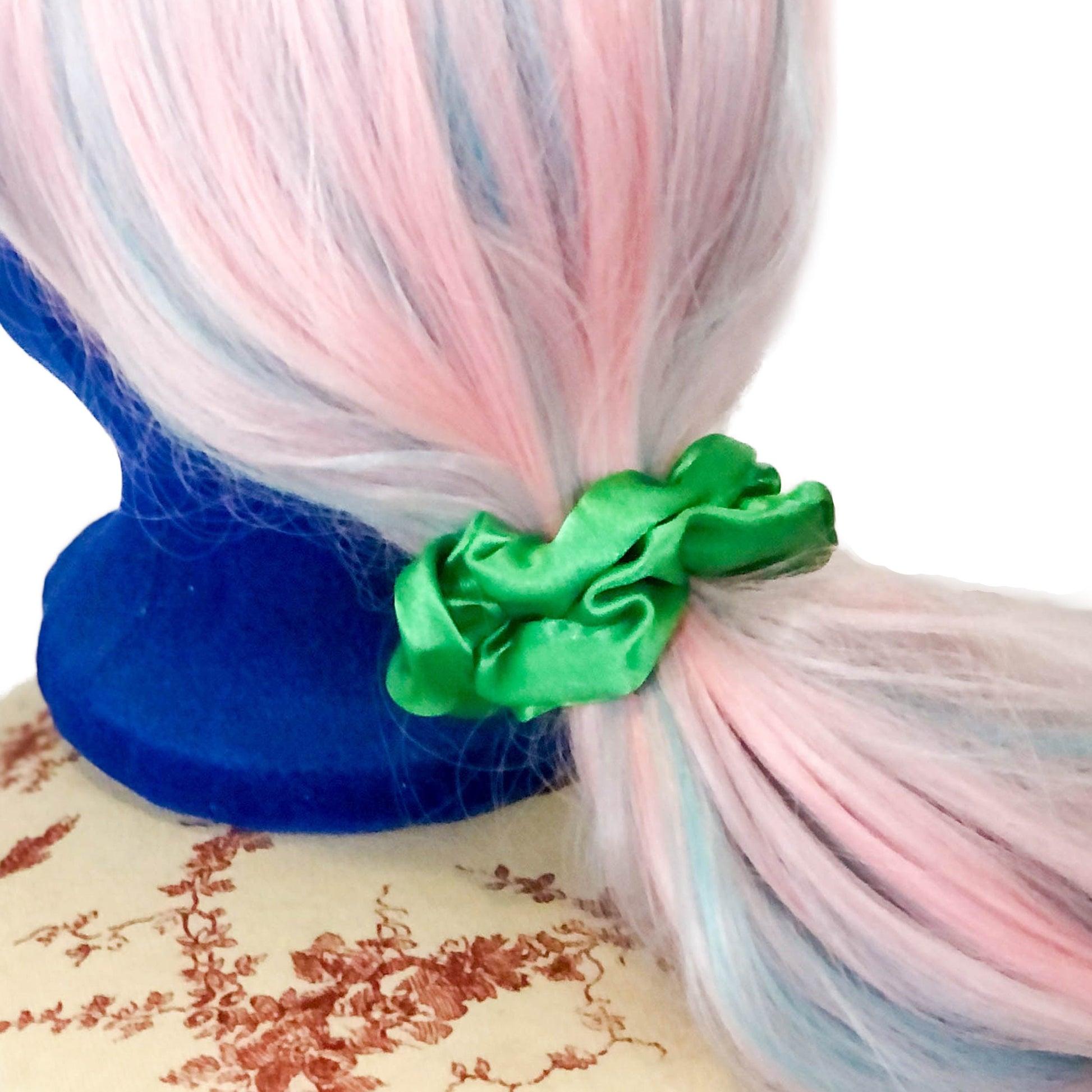 Photo of a shiny green scrunchie on a wig