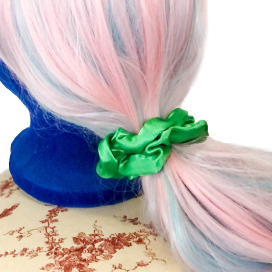 Photo of a shiny green scrunchie on a wig