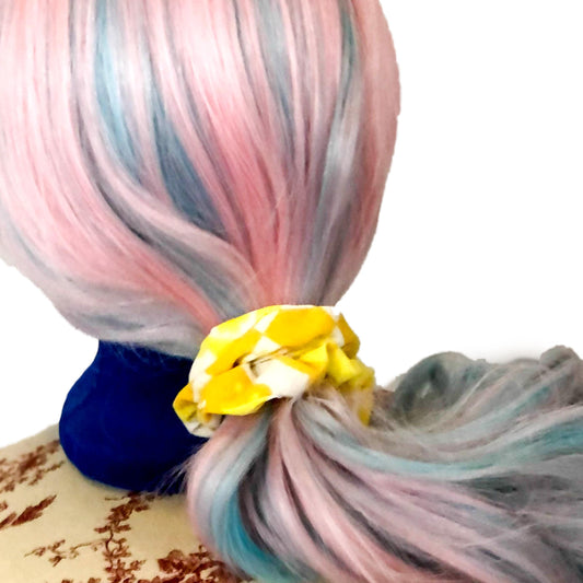 Scrunchie made of yellow and white patterned fabric on a wig