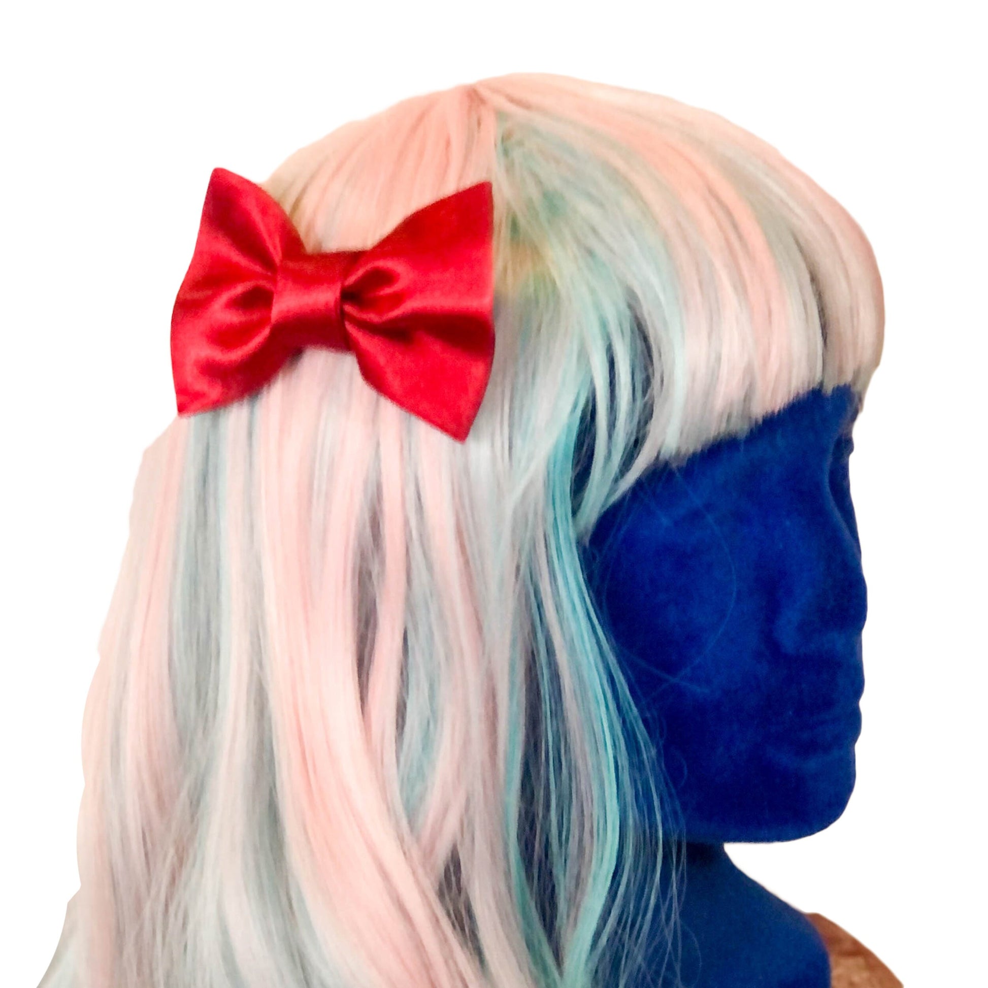 Photo of a hair bow made of red satin on a wig